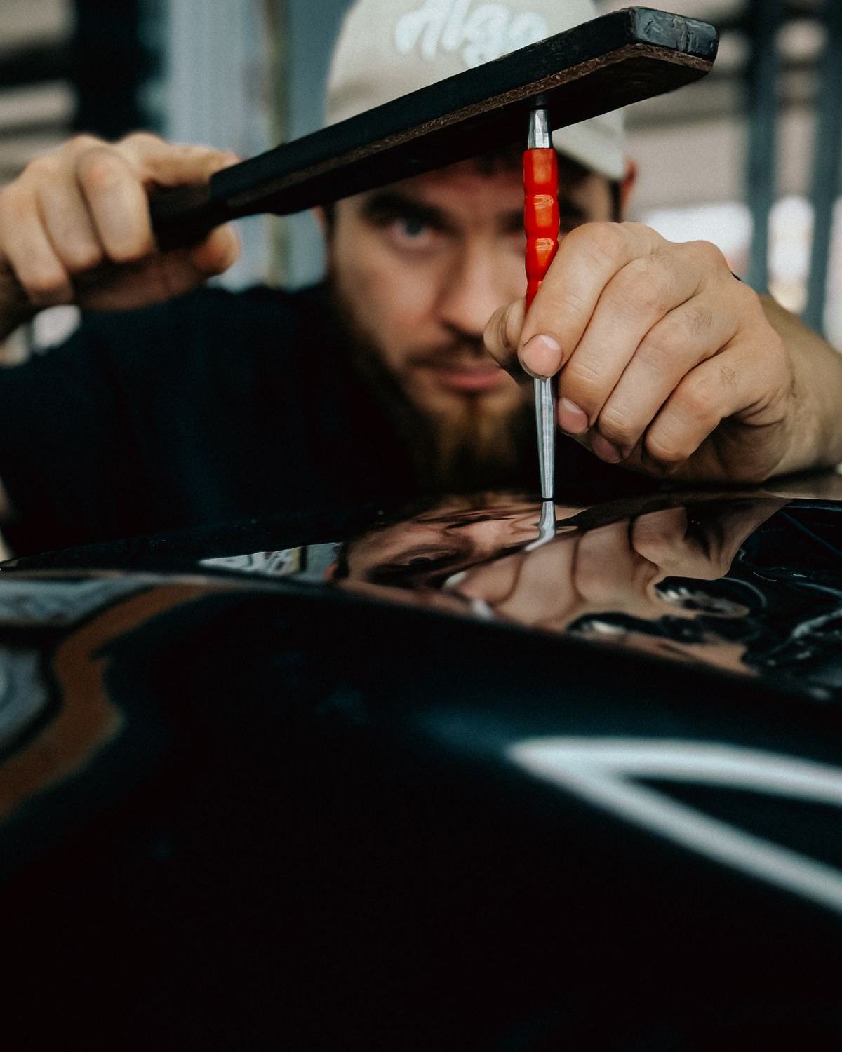 Technician repairing a dent on a car panel