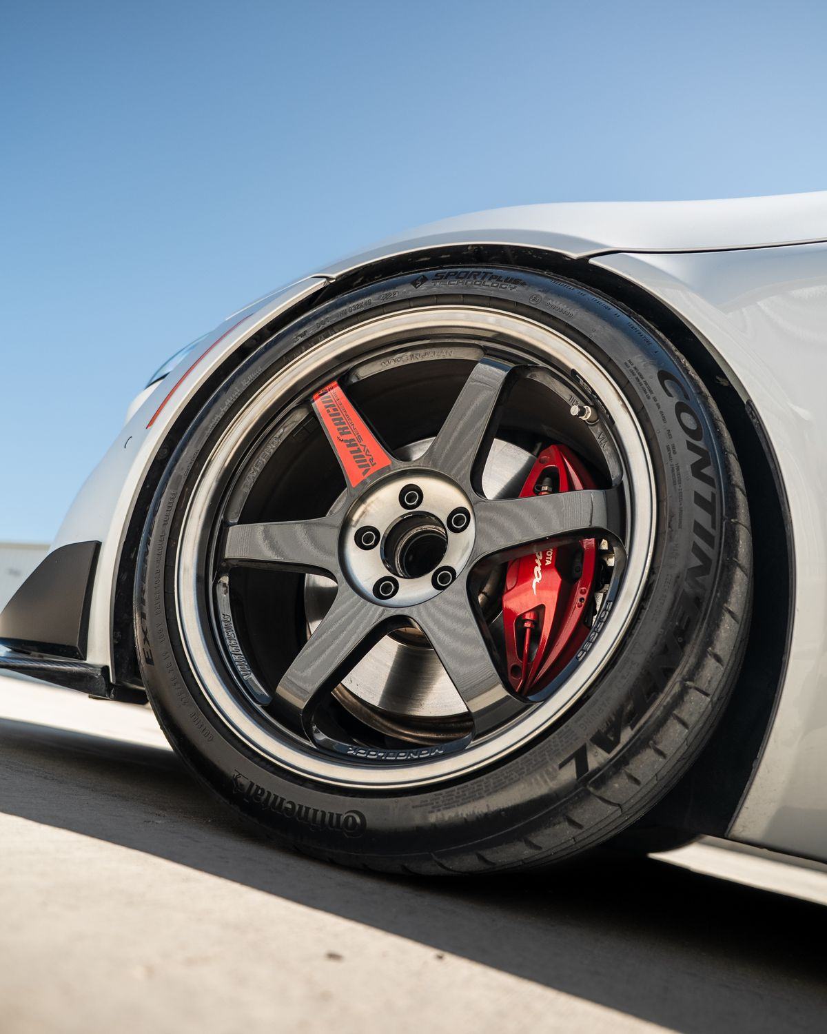 Close-up of a black alloy wheel with red brake caliper